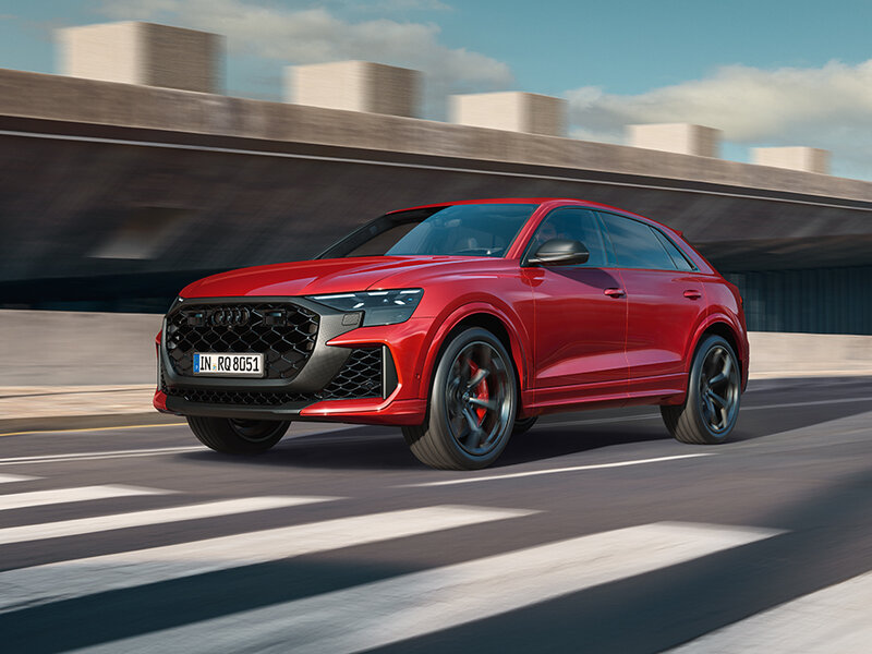 Audi RS Q8 frontal in Bewegung mit großem Singleframe-Grill, sportlichen Lufteinlässen und kraftvollem Auftritt