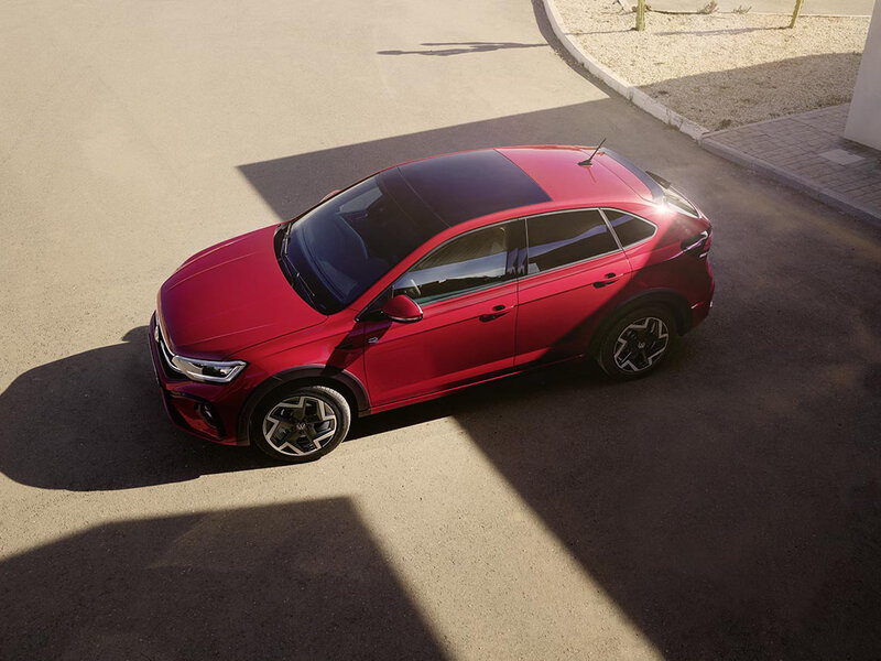 Ein roter Volkswagen Taigo ist aus der Vogelperspektive auf einer Straße abgebildet.