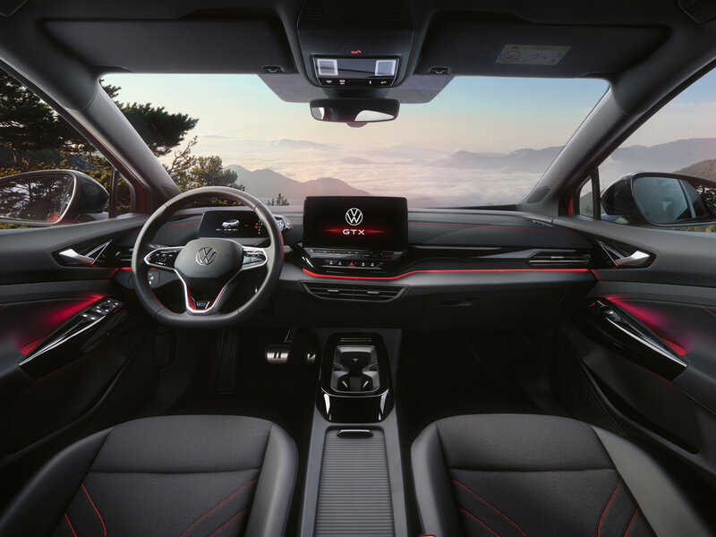 Blick in den Innenraum des VW ID.5 GTX mit digitalem Cockpit, zentralem Touchscreen und beleuchteten Designelementen in dunklem Interieur.