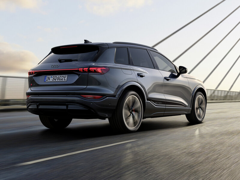 Audi SQ6 e-tron fährt dynamisch auf offener Straße, mit markanter Heckpartie und sportlicher Linienführung