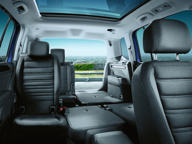 Innenraum eines Volkswagen Touran mit variabler Sitzanordnung, großzügiger Kopffreiheit und umgeklappten Sitzen für flexibles Platzangebot.