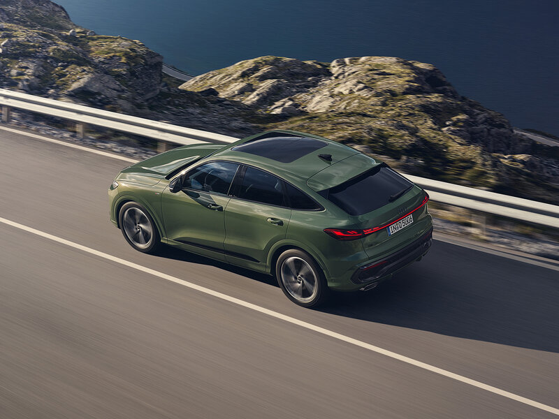 Audi Q5 Sportback in dynamischer Fahrt entlang einer Bergstraße mit flacher Coupé-Dachlinie und markanter SUV-Silhouette
