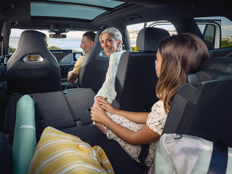 Innenansicht eines Volkswagen Tayron mit mehreren sitzenden Personen auf den Rücksitzen und großzügigem Platzangebot.