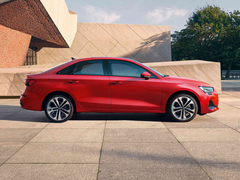 Audi A3 Limousine in Seitenansicht vor moderner Architektur, klare Silhouette und elegantes, dynamisches Design