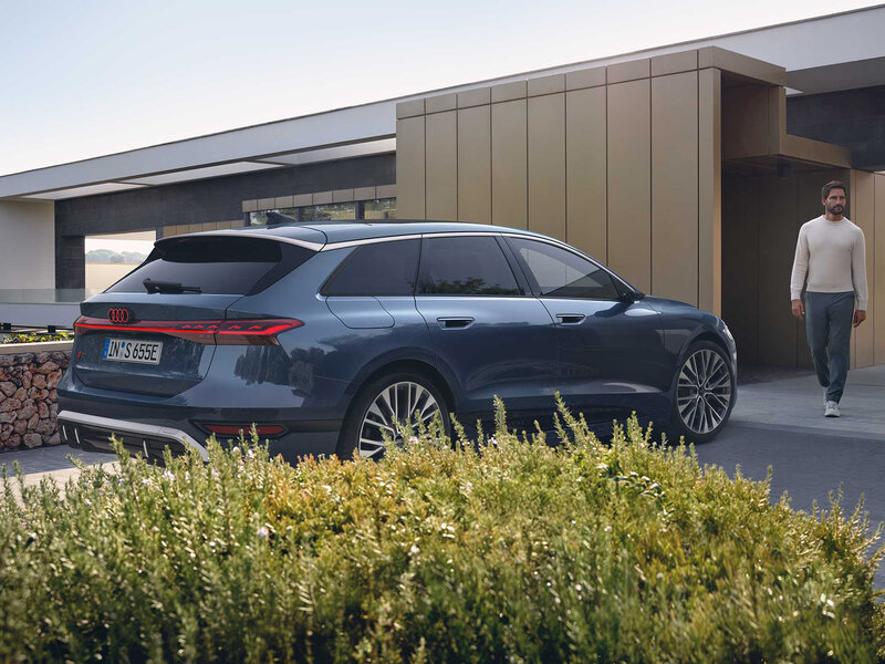 Audi S6 Avant e-tron vor moderner Architektur mit sportlicher Avant-Silhouette und markanter elektrischer Linienführung