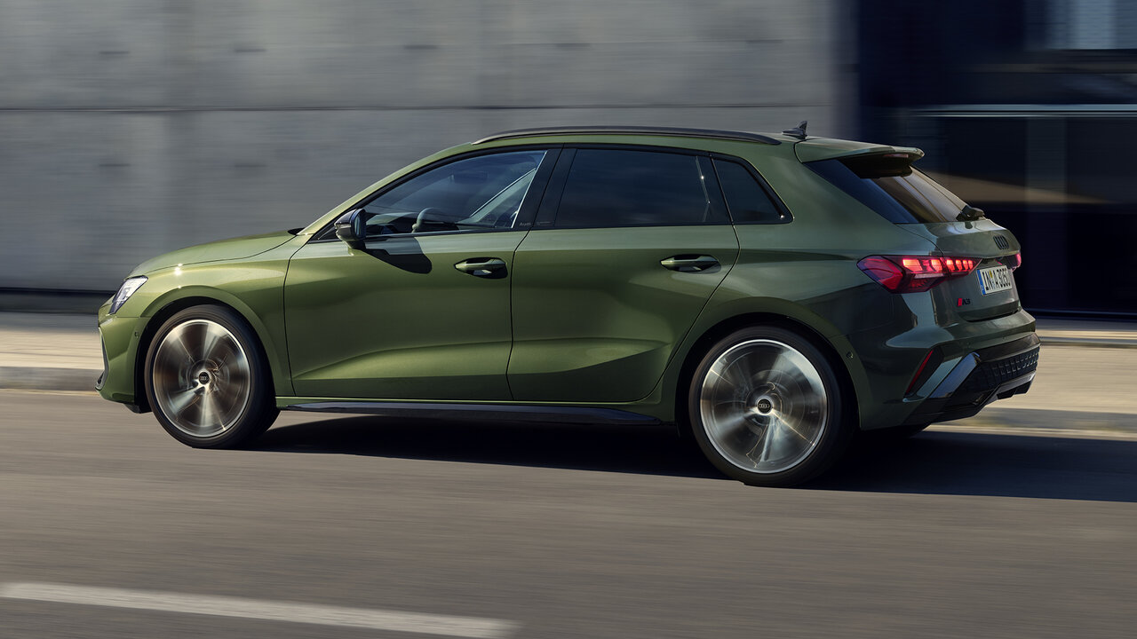 Audi A3 Sportback in Grün, seitliche Fahransicht auf urbaner Straße mit dynamischer Bewegung und sportlichem Auftritt