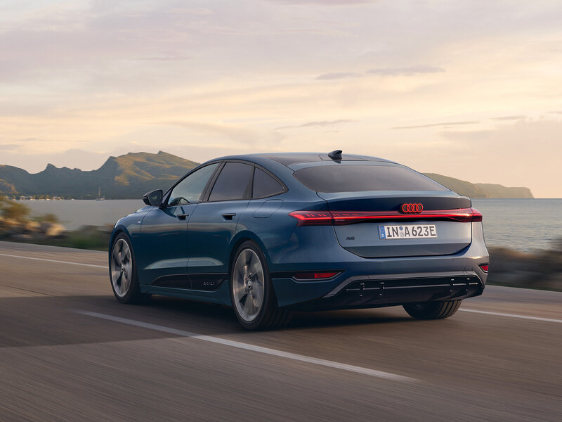 Audi A6 Sportback e-tron in Heckansicht bei Fahrt mit durchgehendem Leuchtenband und sportlicher Coupé-Linie