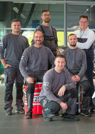 Fünf Werkstattmitarbeiter des Porsche Zentrums im modernen Showroom