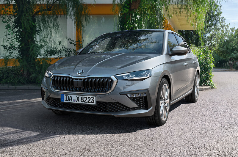 Škoda Scala in Grau steht auf einer Straße vor einem begrünten Gebäude bei Tageslicht