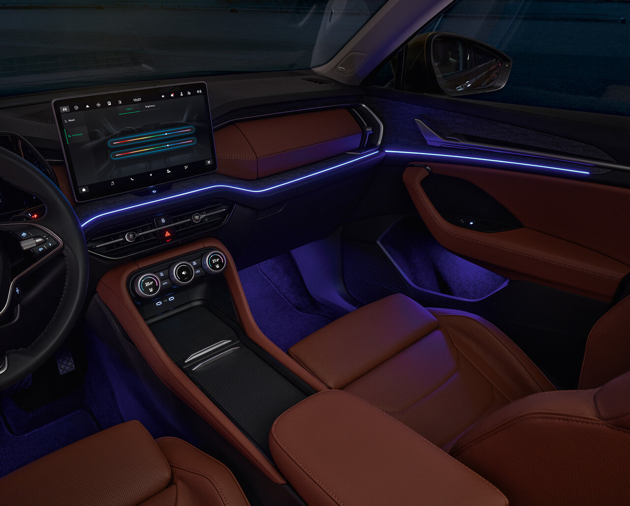 Innenraum des Škoda Kodiaq mit braunen Sitzen, zentralem Display und blauer Ambientebeleuchtung bei Dunkelheit.