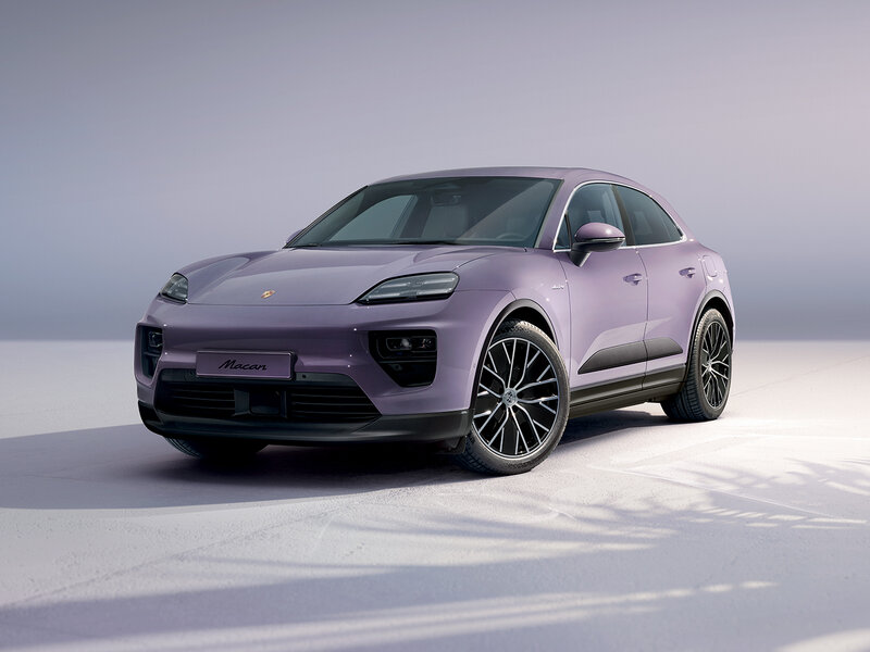 Ein vollelektrischer Porsche Macan in violetter Lackierung steht in einem hellen Studio vor neutralem Hintergrund.