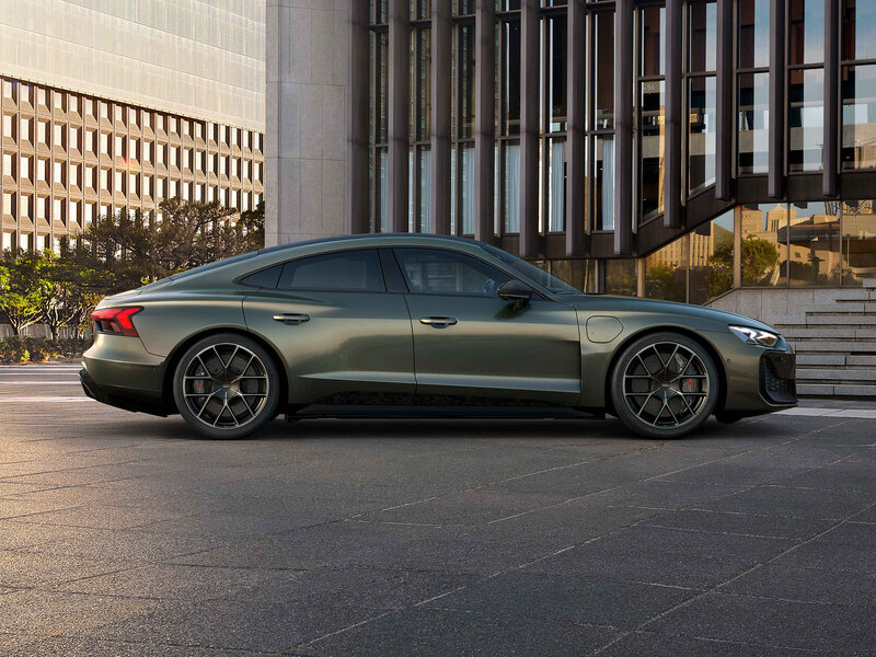 Audi RS e-tron GT performance in Seitenansicht vor moderner Architektur mit breitem Stand