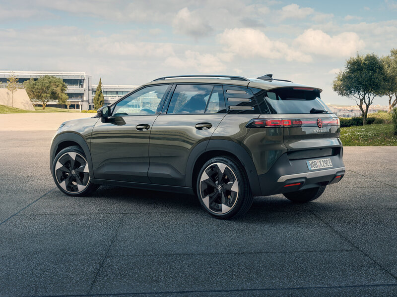 Volkswagen ID. Cross in Heck-Dreiviertelansicht auf einer befestigten Fläche vor moderner Architektur