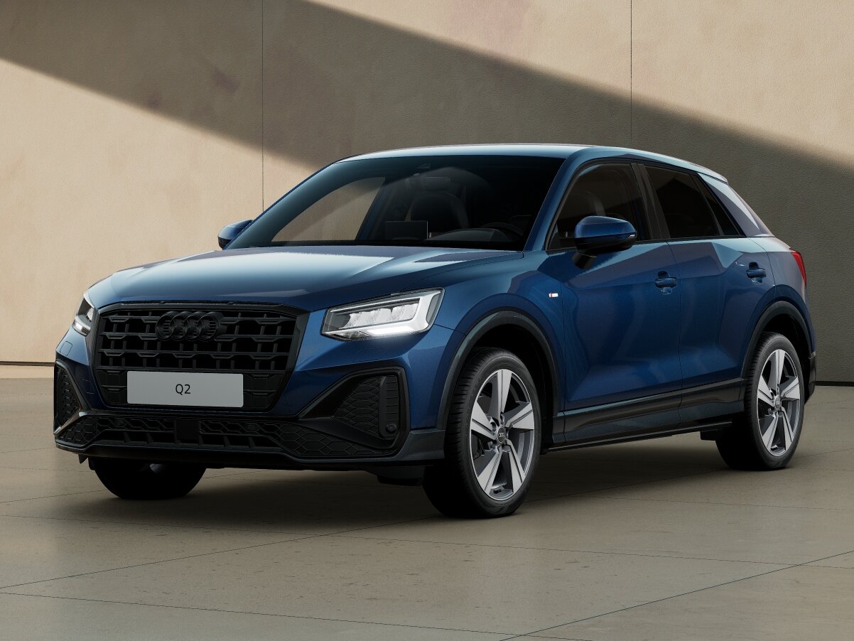 Audi Q2 in Frontansicht schräg von vorn vor moderner Architektur mit markantem Singleframe-Grill und LED-Scheinwerfern