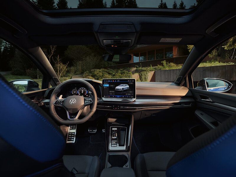 Innenansicht eines Volkswagen Golf R mit digitalem Cockpit, zentralem Infotainmentdisplay und sportlich gestaltetem Fahrerbereich.