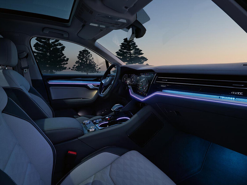 Innenansicht eines Volkswagen Touareg mit großem Touchscreen, digitalem Cockpit und Ambientebeleuchtung.
