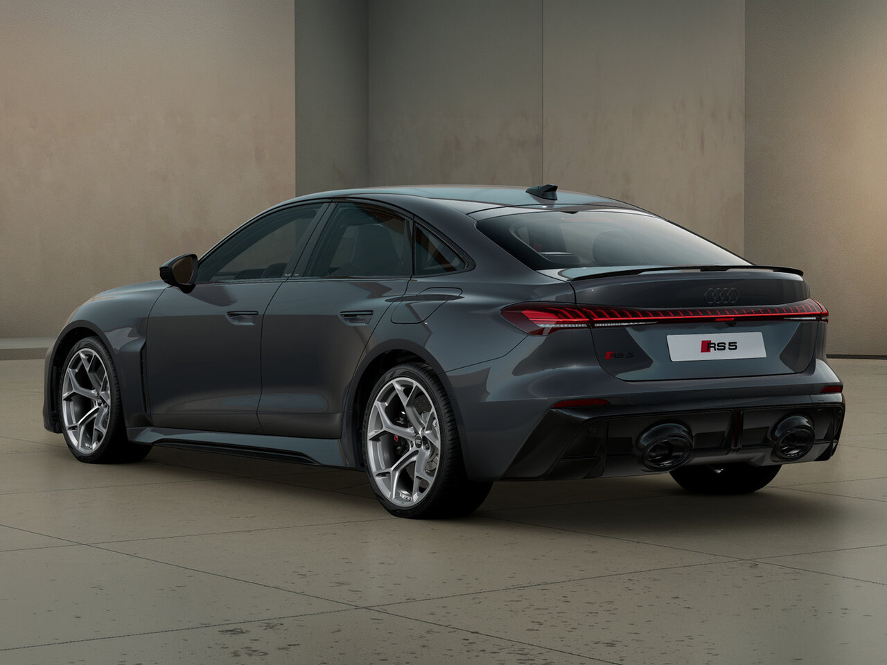 Audi RS5 Limousine in Heckansicht schräg von hinten vor moderner Architektur mit durchgehendem LED-Leuchtenband, Heckspoiler und RS-Diffusor