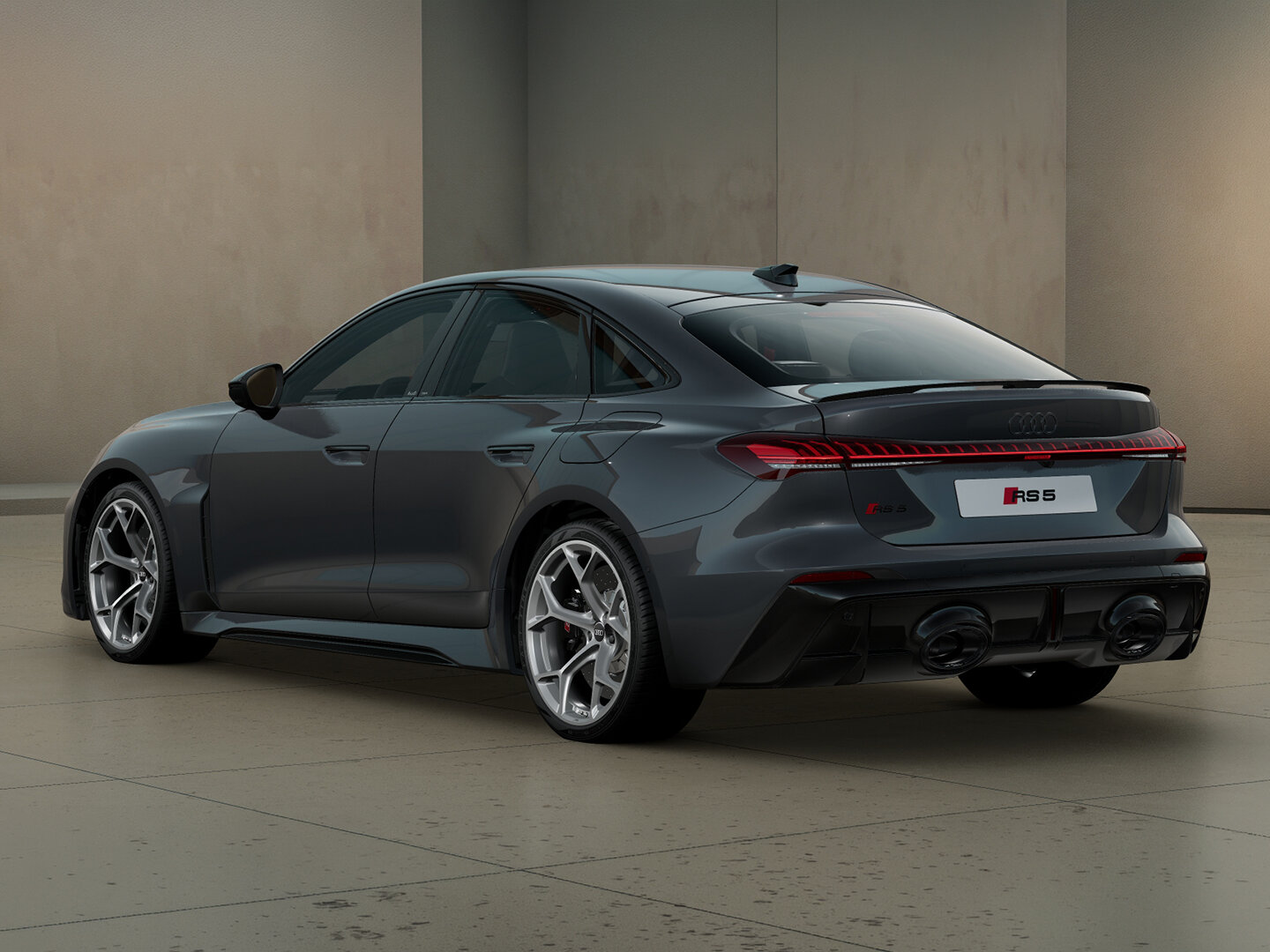 Audi RS5 Limousine in Heckansicht schräg von hinten vor moderner Architektur mit durchgehendem LED-Leuchtenband, Heckspoiler und RS-Diffusor