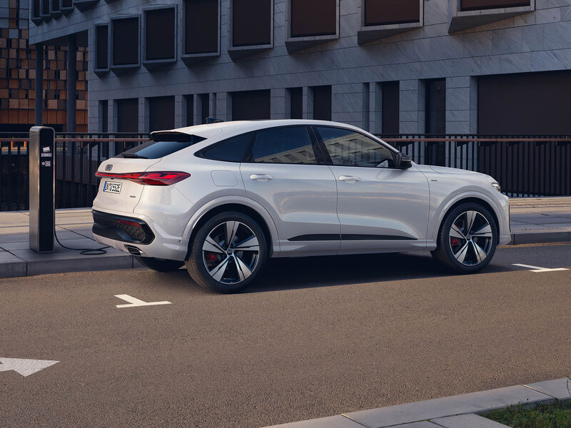 Audi Q5 Sportback e-hybrid vor urbaner Architektur mit sportlichem Design, Plug-in-Hybrid-Technologie und elegantem Auftritt
