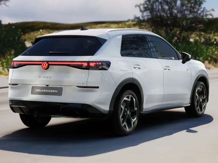 Volkswagen T-Roc in weißer Lackierung aus Heck-Perspektive auf befestigter Fläche geparkt