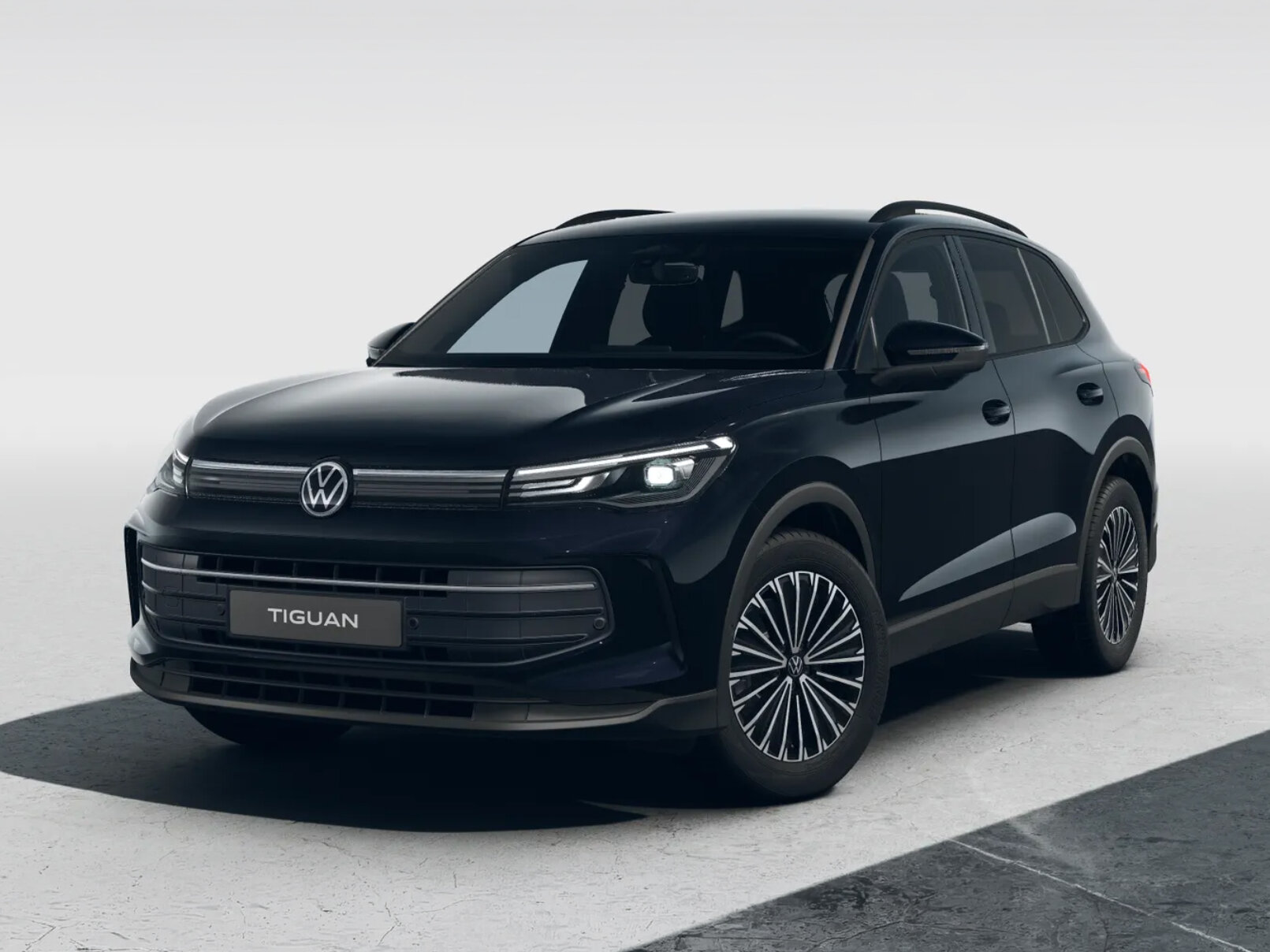 Schwarzer Volkswagen Tiguan in Frontansicht schräg von der Seite vor neutralem hellem Hintergrund