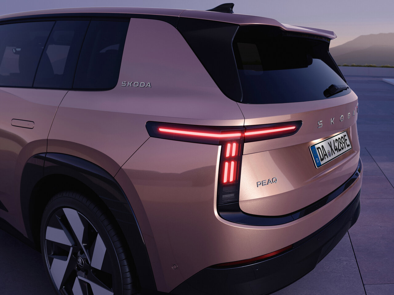 Heckansicht des neuen Škoda Peaq mit beleuchteten Rückleuchten, Modellschriftzug und modernem SUV-Design.