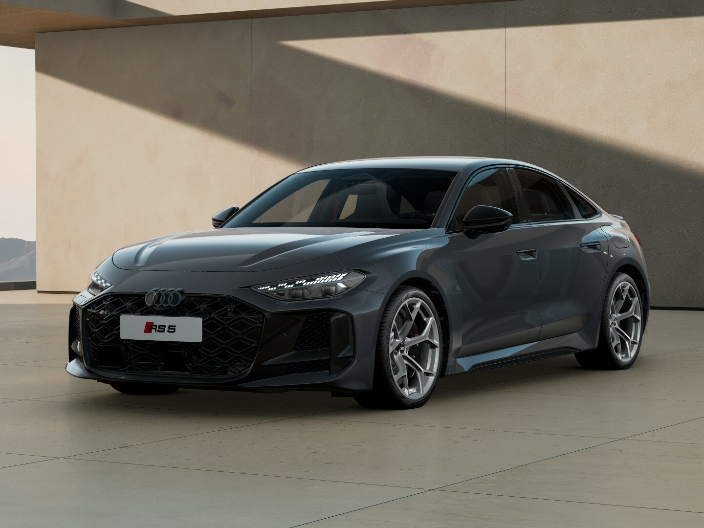 Audi RS5 Limousine in Frontansicht schräg von vorn vor moderner Architektur mit markantem RS-Kühlergrill, schmalen LED-Scheinwerfern und Sportfelgen