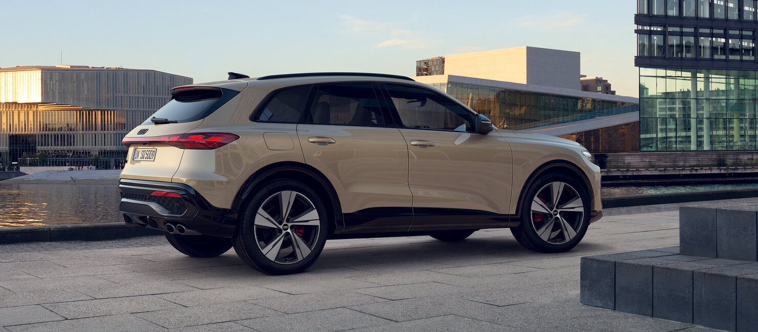 Audi SQ5 in heller Lackierung seitlich geparkt auf modernem Platz, kraftvolle Proportionen und sportliche Linienführung