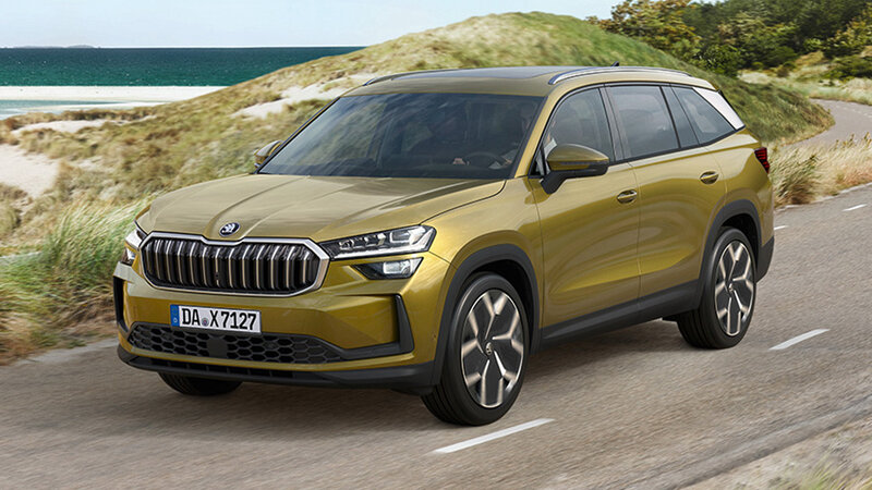 Škoda Kodiaq in Gold-Bronze Metallic fährt auf einer Küstenstraße mit Dünen und Meer im Hintergrund bei sonnigem Wetter.