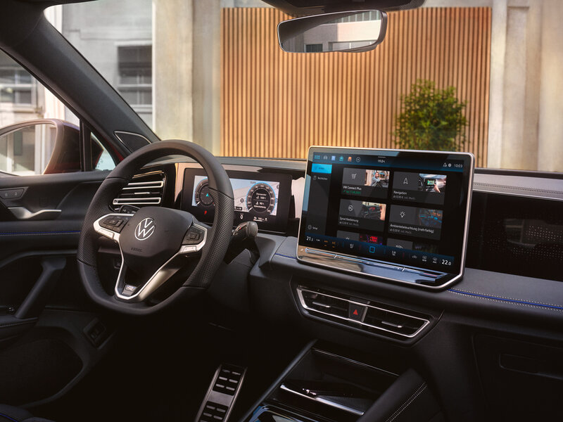 Innenansicht eines Volkswagen Tiguan mit digitalem Cockpit, großem Infotainmentdisplay und Lenkrad aus der Fahrerperspektive.