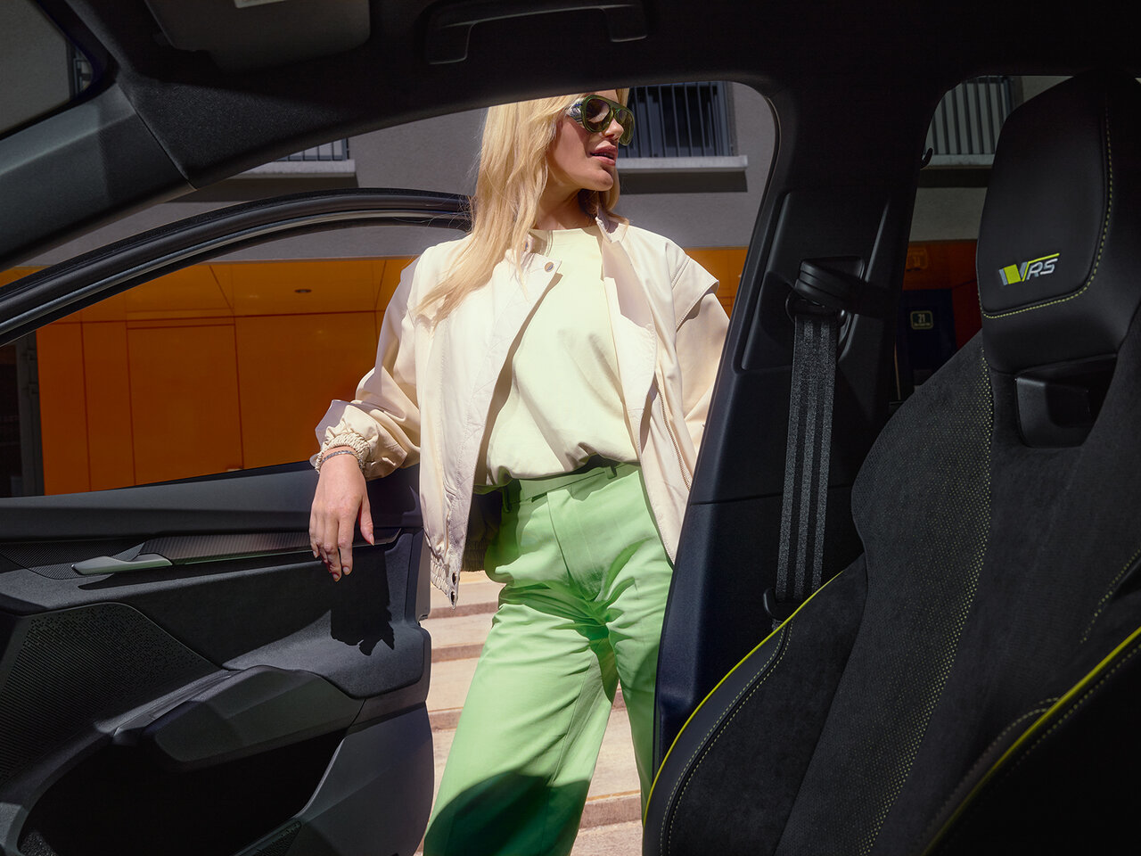 Innenansicht des Škoda Elroq RS mit Sportsitzen, im Hintergrund steht eine Frau neben der geöffneten Tür.