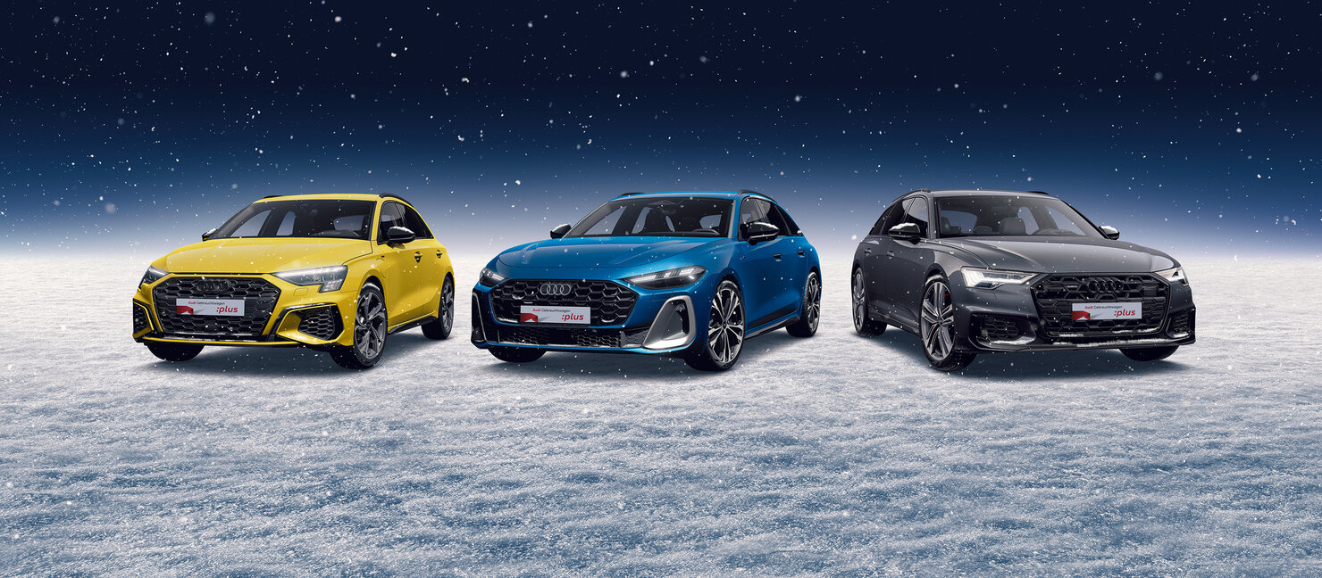 Drei Audi Modelle in Gelb, Blau und Schwarz stehen nebeneinander auf schneebedecktem Boden unter klarem Nachthimmel