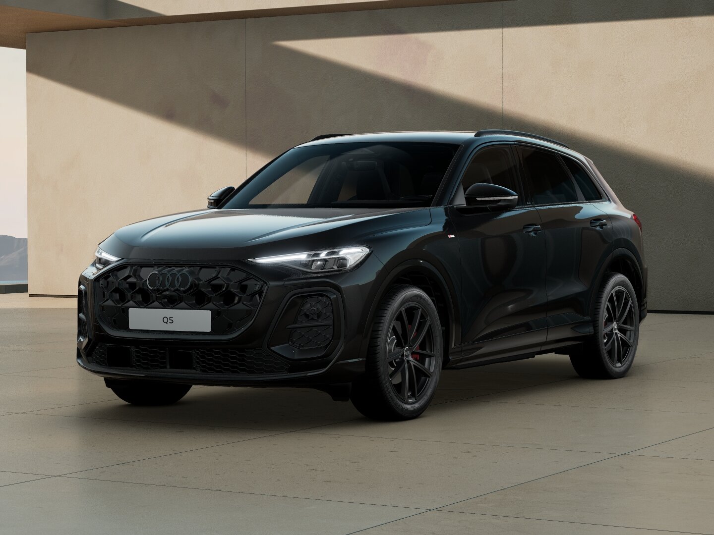 Audi Q5 in Frontansicht schräg von vorn vor moderner Architektur mit markantem Singleframe-Grill, LED-Scheinwerfern und dunklen Leichtmetallrädern