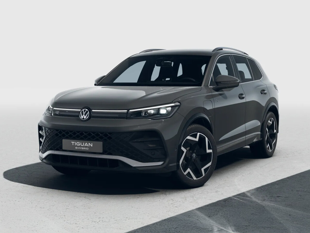 Volkswagen Tiguan eHybrid in Dunkelgrau aus schräger Frontansicht in einem neutralen Studio fotografiert