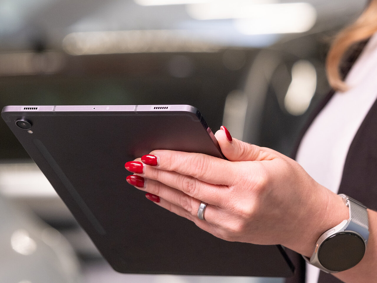 Frau hält ein Tablet in der Hand in der Fahrzeugausstellung des Auto Bach Autohauses