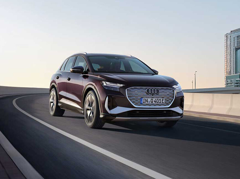Audi Q4 e-tron fährt auf der Straße mit klarer Linienführung, markantem Singleframe und moderner Lichtsignatur