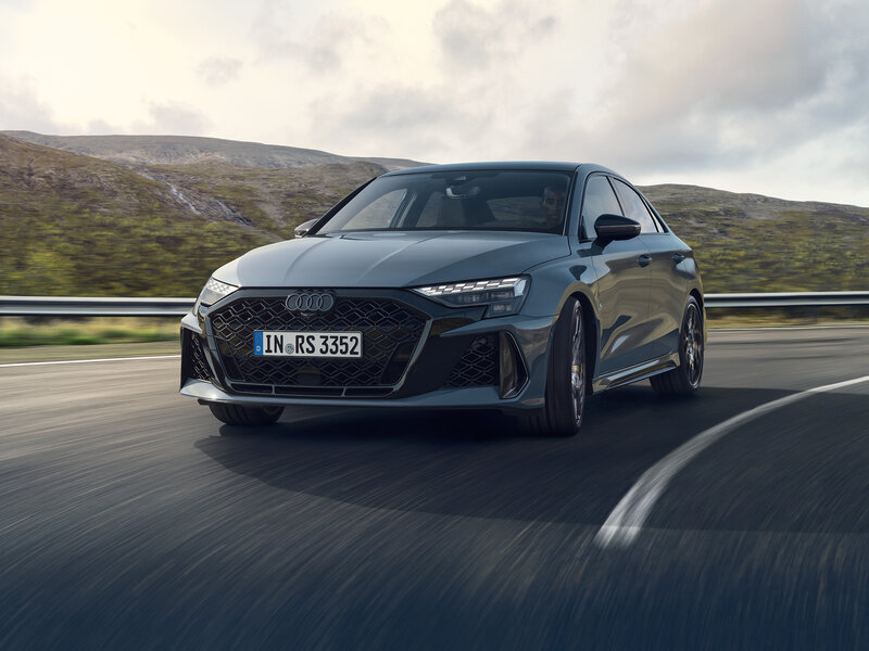 Audi RS 3 Limousine in dynamischer Frontansicht auf kurviger Straße mit markantem RS-Grill und sportlicher Optik