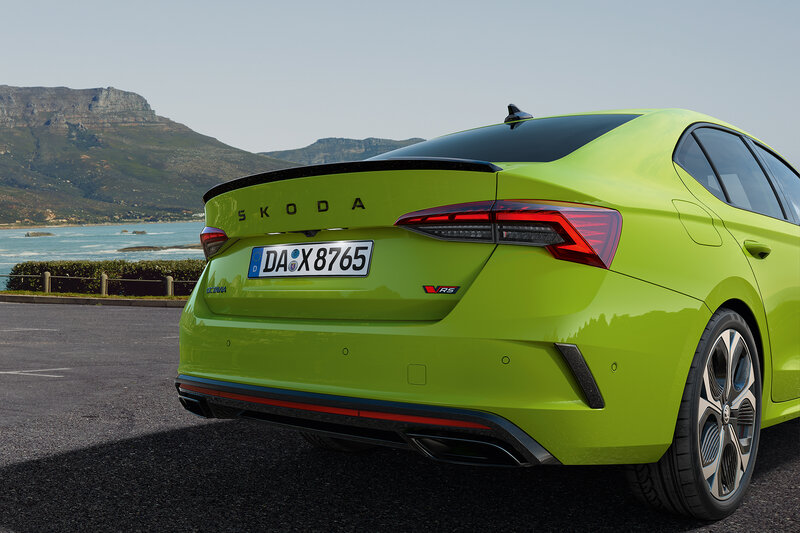 Heckansicht des Škoda Octavia RS Limousine in Mamba-Grün mit schwarzem Spoiler vor Berg- und Meerkulisse