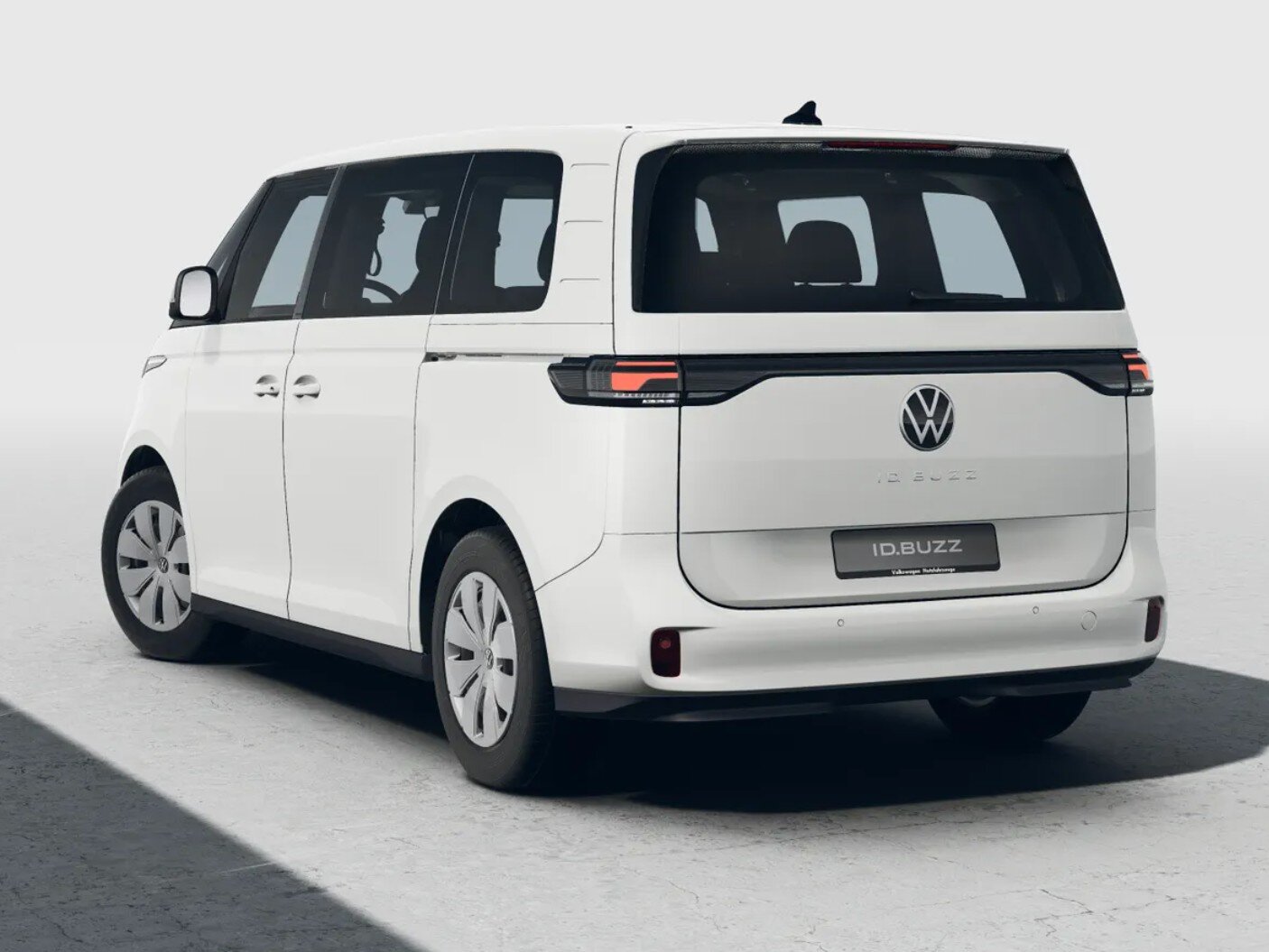 Weißer Volkswagen ID. Buzz in Heckansicht steht freigestellt vor hellem Studiohintergrund
