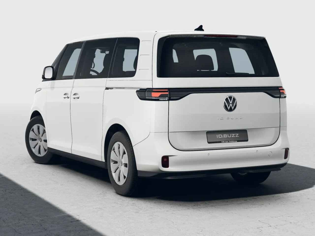 Weißer Volkswagen ID. Buzz in Heckansicht steht freigestellt vor hellem Studiohintergrund