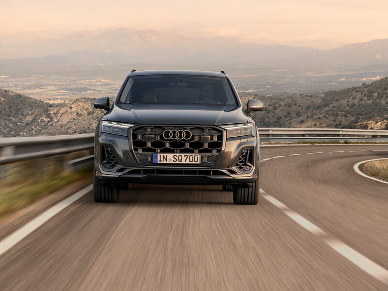 Audi SQ7 von vorn auf kurviger Straße mit markantem Grill, breitem Stand und sportlichem SUV-Design