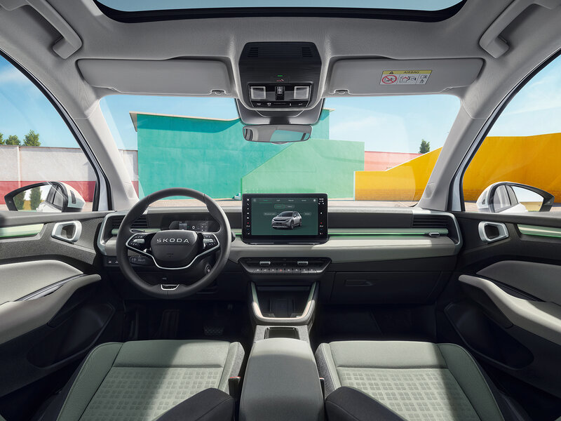 Cockpit des Škoda Epiq mit zentralem Display, Lenkrad und Blick durch die Frontscheibe auf urbane Umgebung
