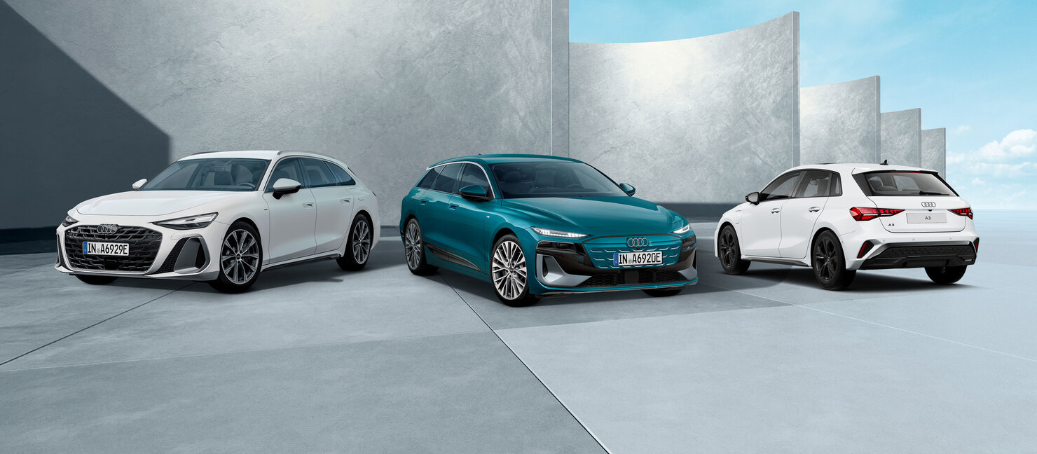 Audi A6 Avant, A6 Avant e-tron und A3 Sportback nebeneinander vor moderner Betonarchitektur in seitlicher Perspektive