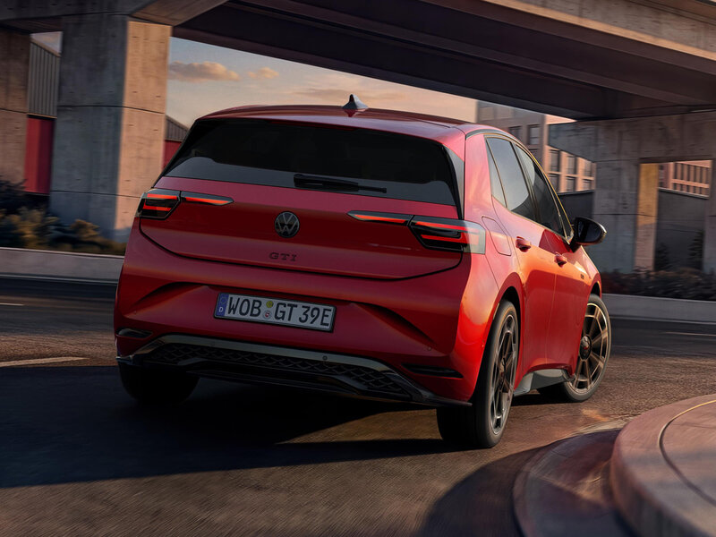 Roter Volkswagen ID.3 GTI aus der Heckperspektive auf einer Straße unter einer Betonbrücke bei tief stehender Sonne