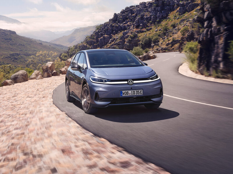 Volkswagen ID.3 Neo fährt auf kurviger Bergstraße aus Frontperspektive entlang felsiger Landschaft bei sonnigem Wetter