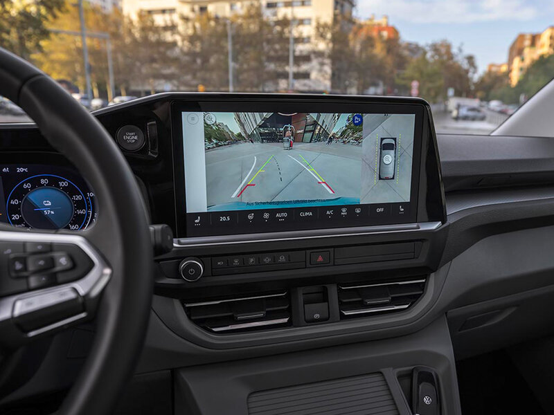 Zentrales Display im Volkswagen Caravelle mit aktiver Rückfahrkameraansicht, Fahrbahnmarkierungen und Umgebungsanzeige.