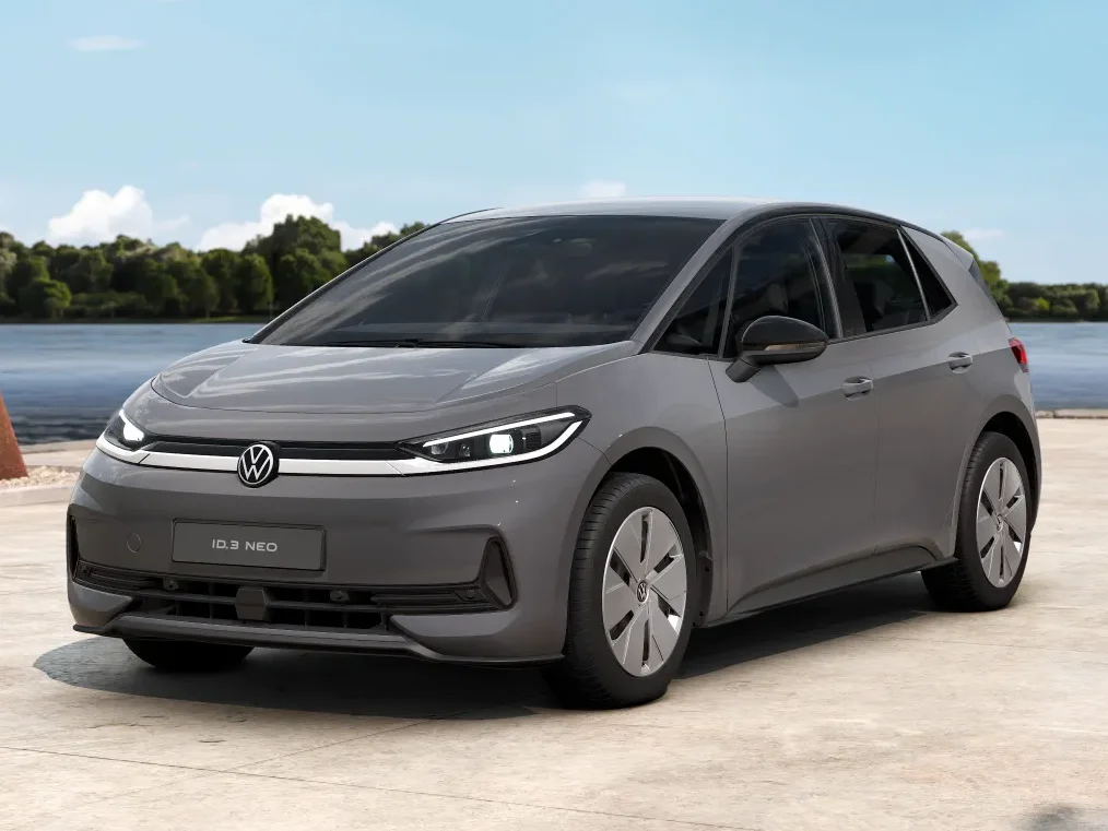 Grauer Volkswagen ID.3 Neo Trend steht auf einer hellen Fläche mit Wasser als Hintergrund
