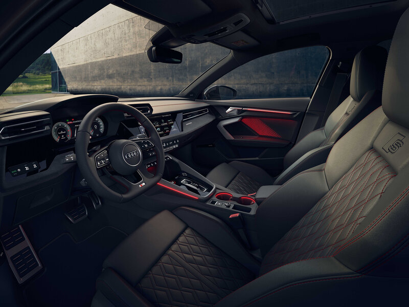 Innenraum des Audi S3 Sportback mit Sportsitzen, digitalem Cockpit, roten Akzenten und hochwertiger Verarbeitung