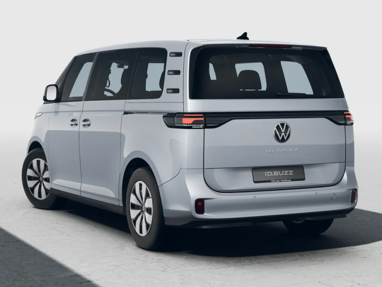 Volkswagen ID. Buzz in Silber auf neutralem Hintergrund, Fokus auf Rückleuchten, Heckklappe und Fahrzeugform