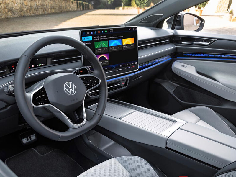 Innenraum des Volkswagen ID.7 mit digitalem Cockpit, großem Touchscreen und multifunktionalem Lenkrad.